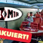 Stillstehender Euro-Mir-Zug im Europa-Park mit sitzenden und stehenden Fahrgästen, die auf eine Evakuierung warten. Schriftzug „Evakuiert!“ im Vordergrund.