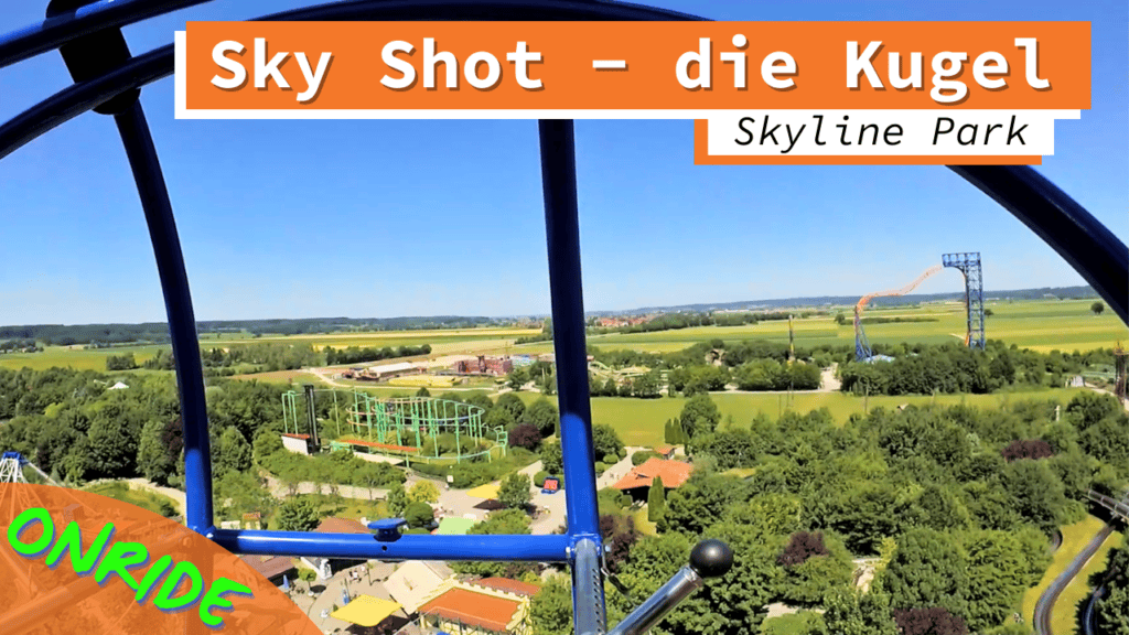 Onride-Ansicht des Fahrgeschäfts Sky Shot im Skyline Park. Die Aufnahme zeigt die Aussicht aus einer kugelförmigen Gondel in luftiger Höhe über den Park und die umliegende Landschaft. Die Gondelstruktur ist blau, und im Hintergrund sind weitere Attraktionen sowie grüne Felder und Bäume zu sehen.
